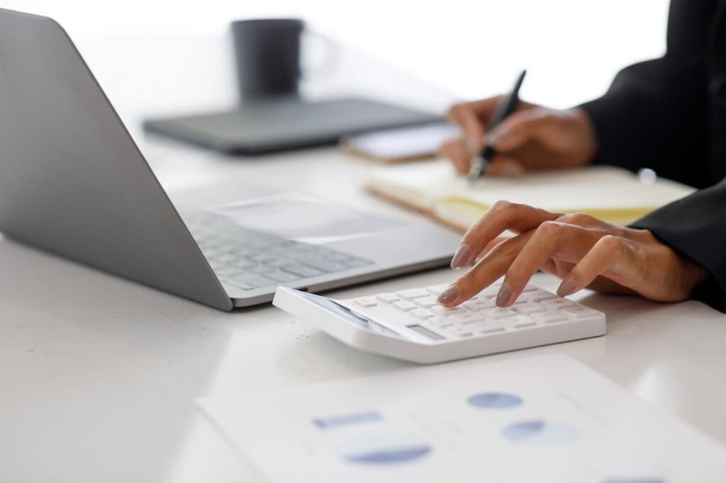 Close up of businesswoman Accounting using calculating income-expenditure and analyzing real estate