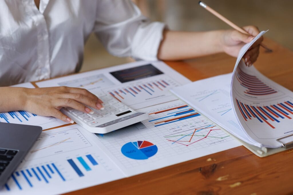 Close up of businesswoman Accounting using calculating income-expenditure and analyzing real estate