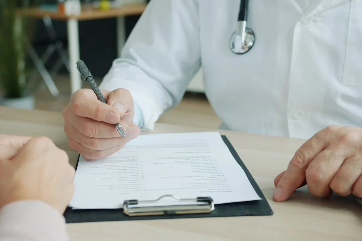 Doctor completing a patient chart in clinic