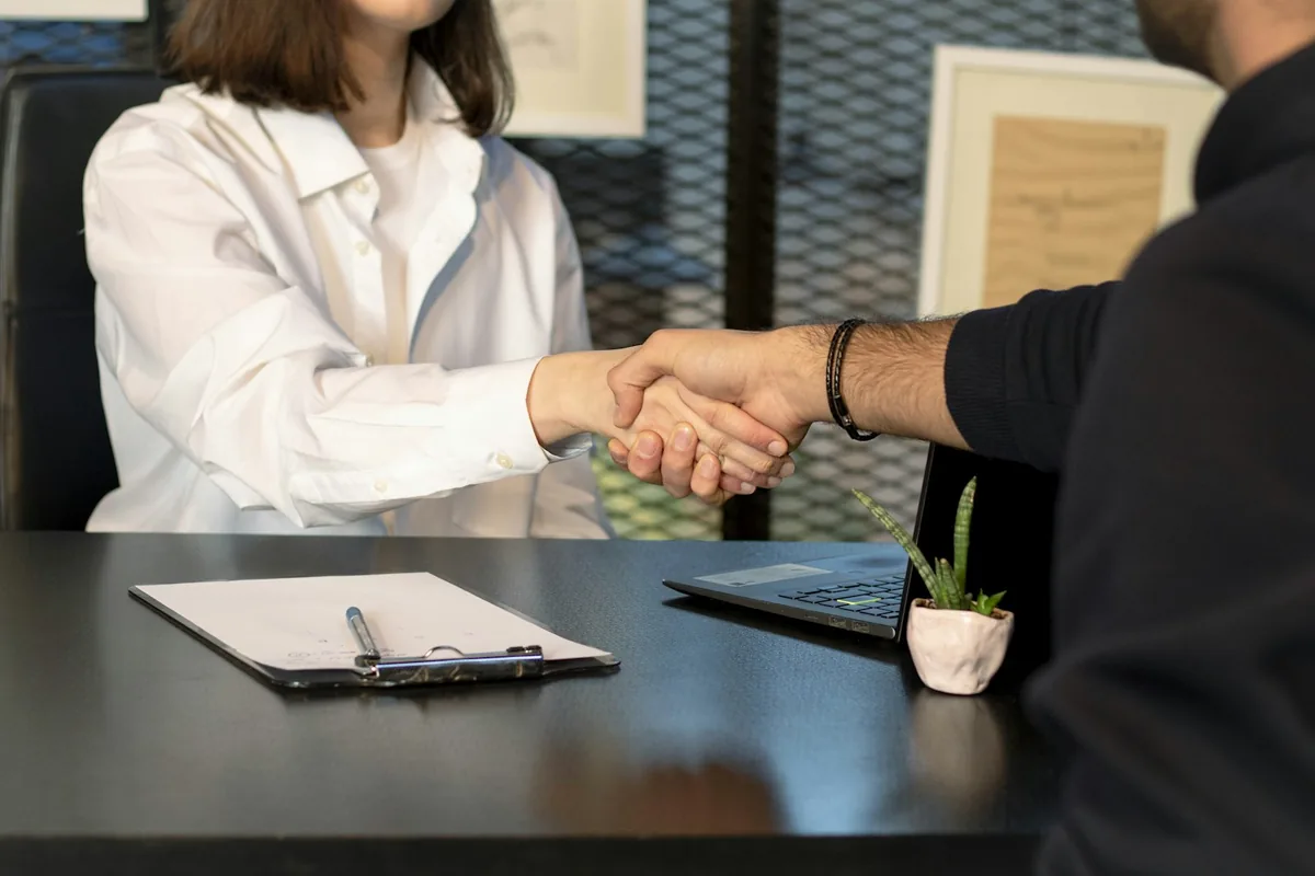 Business sale agreement discussed at a laptop