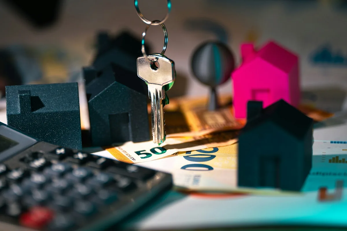 House model, key and calculator for a home sale