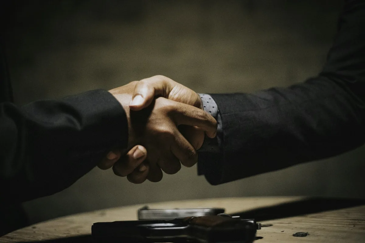 Business partners shaking hands over a table