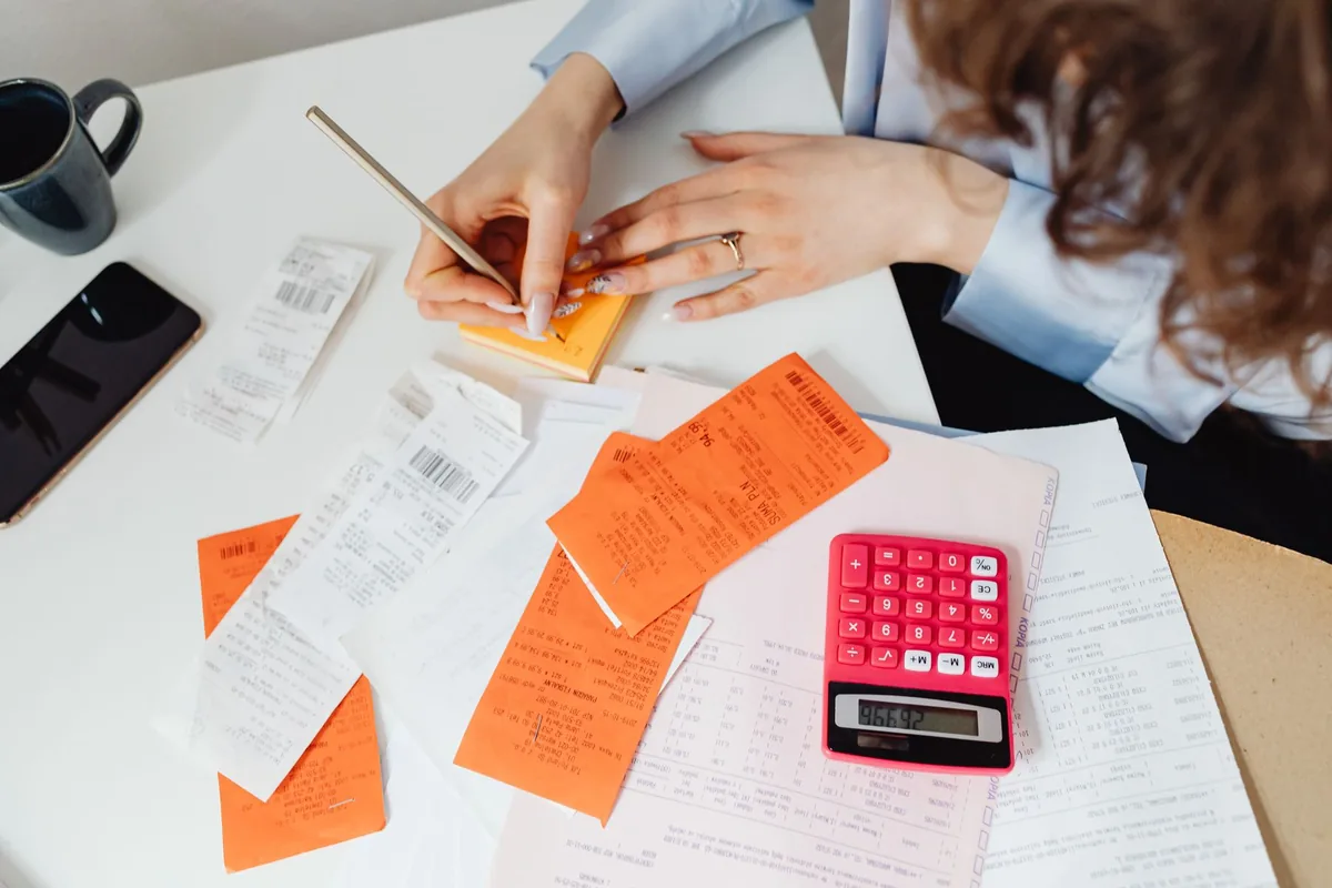 Bookkeeper calculating expenses from receipts and records