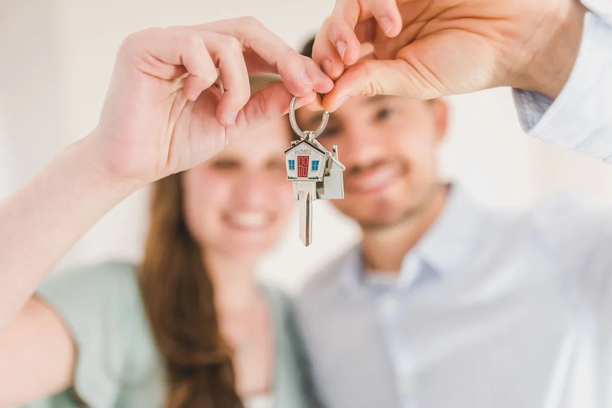 Couple holding the keys to a home they saved to buy