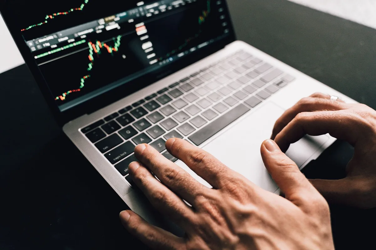 Investor reviewing market charts on a laptop