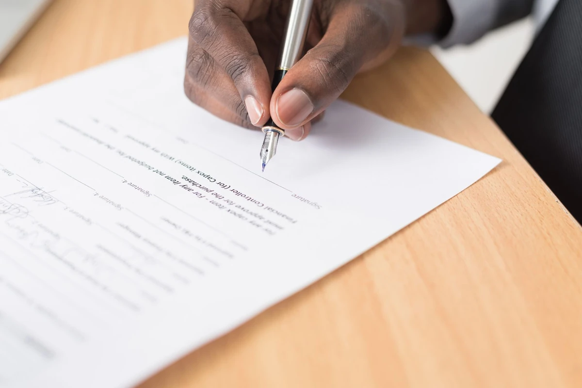 Hand signing a formal document with a pen