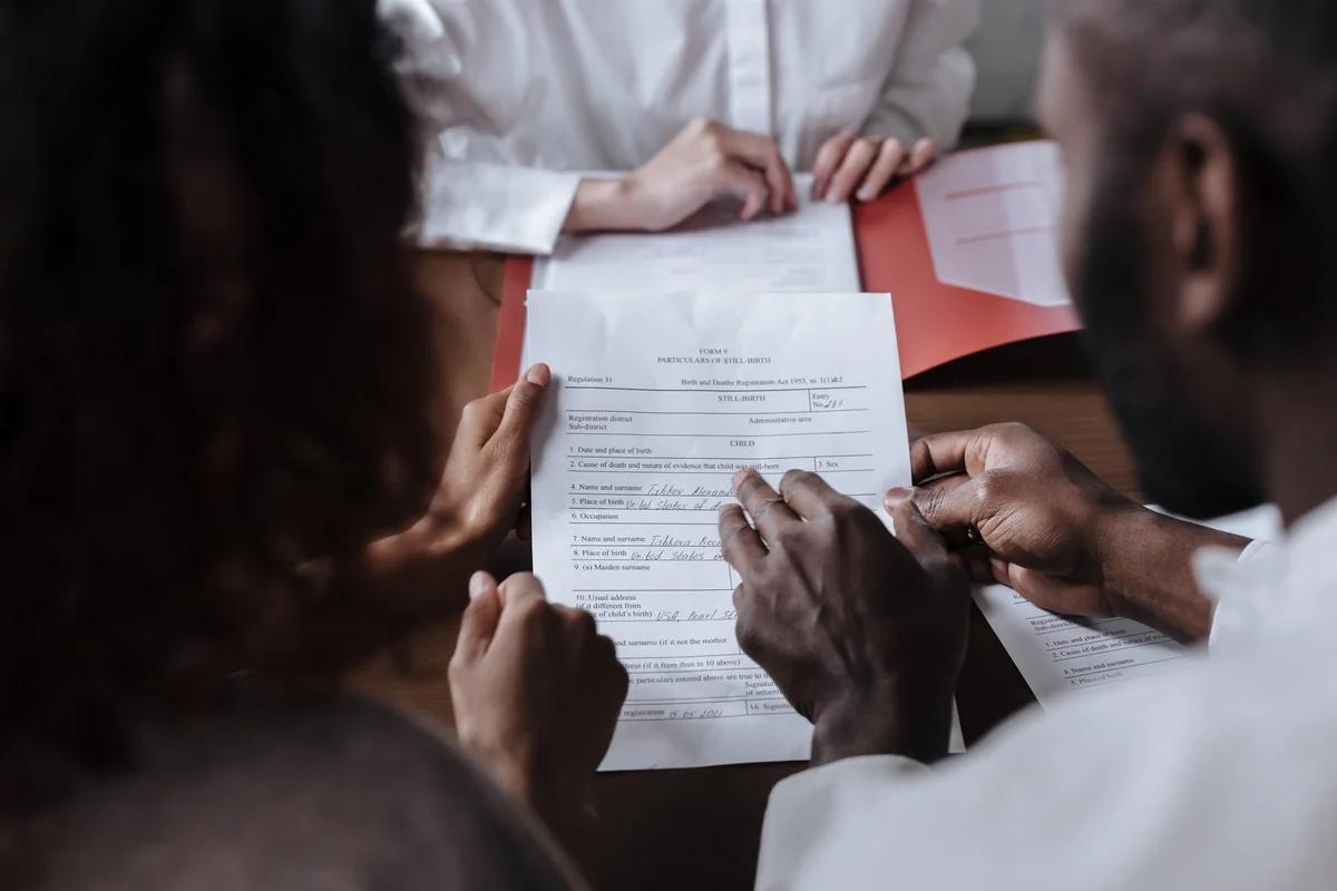 Couple signing legal documents with an advisor