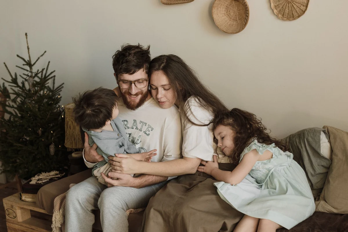 Family sitting together and embracing on a sofa