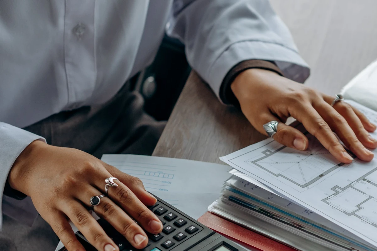 Accountant using a calculator beside financial documents