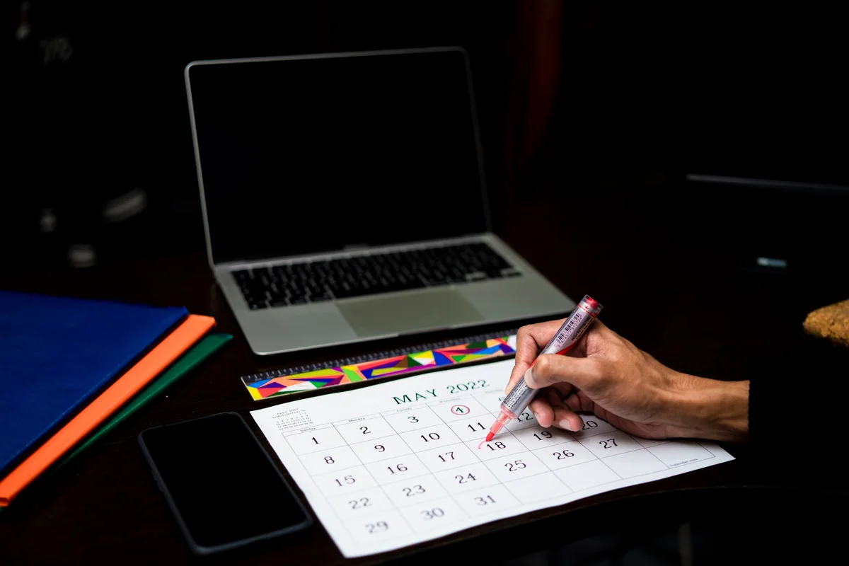 Person marking a deadline on an office calendar