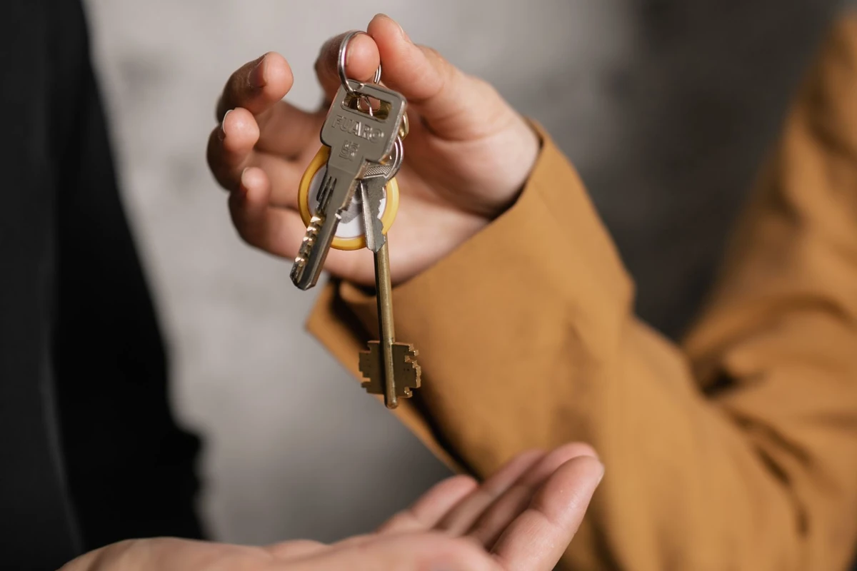 Hands passing house keys to a new owner