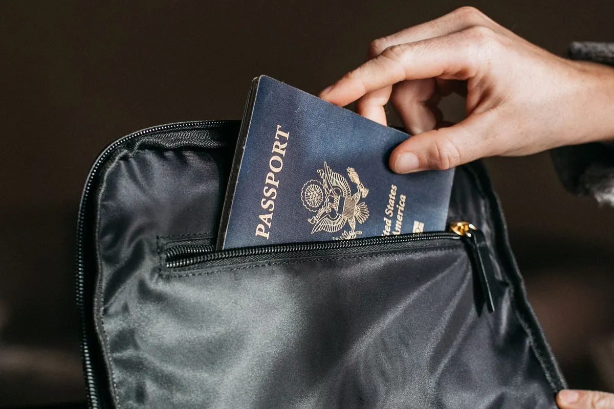 Traveller putting a passport into a bag