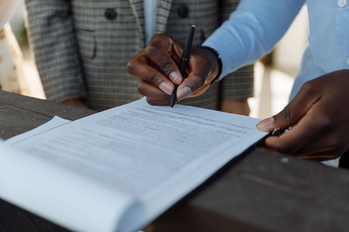 Business professionals signing a document together