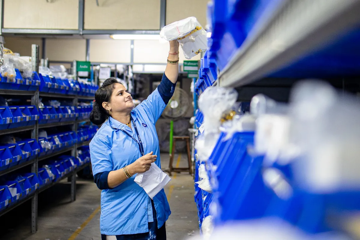 Worker organising inventory on warehouse shelves