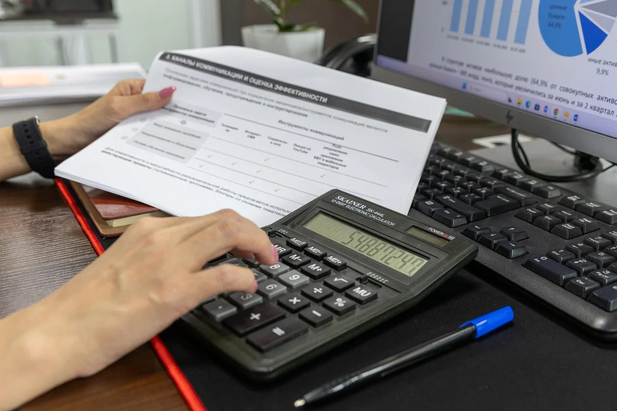 Person calculating figures on a financial document