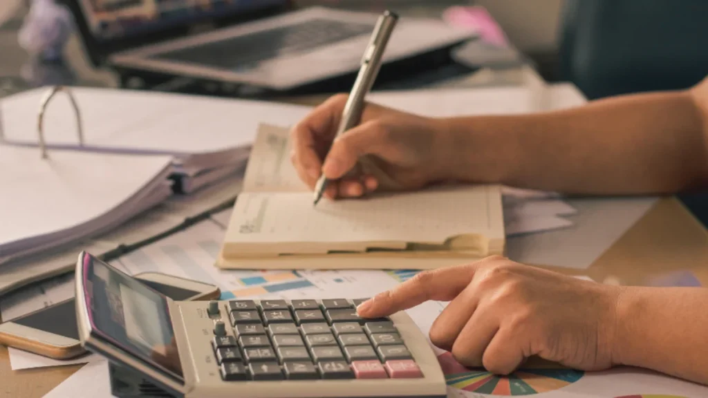 Accountant calculating CRA tax instalments with a calculator and notebook
