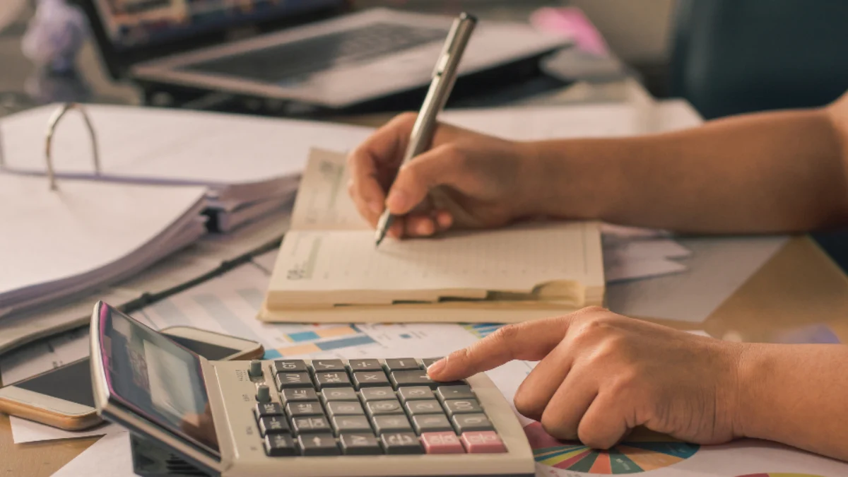 Accountant calculating CRA tax instalments with a calculator and notebook