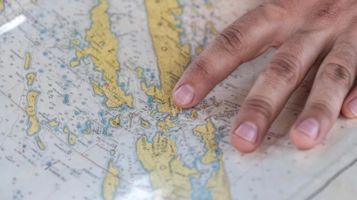 Hand pointing at a map while planning to expand a company into another province