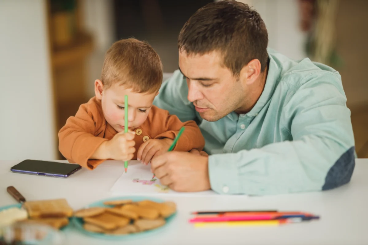 Father and young son drawing together, the next generation in 21-year rule planning
