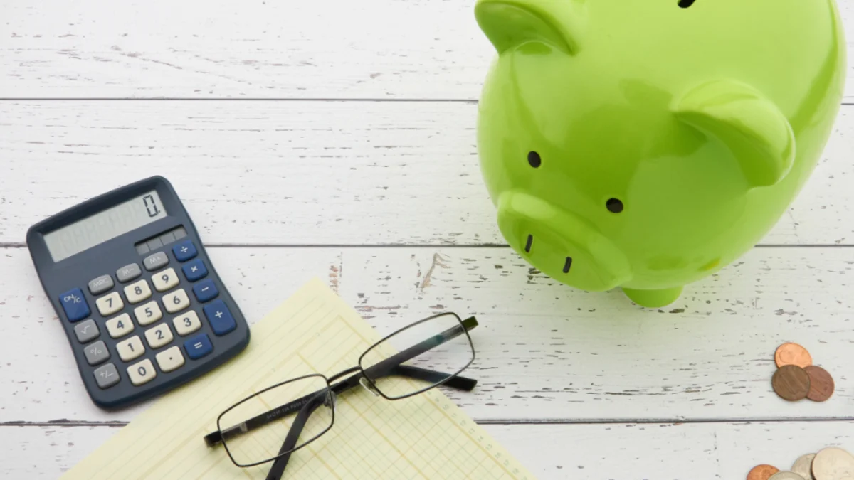 Piggy bank, calculator and ledger representing a corporation's retained earnings