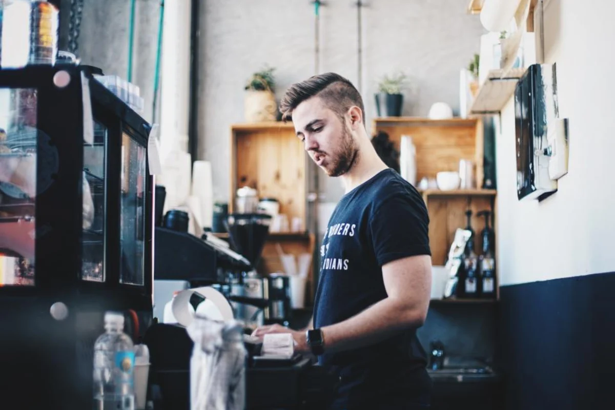 Shop owner behind the counter, a seller who must register for Saskatchewan PST
